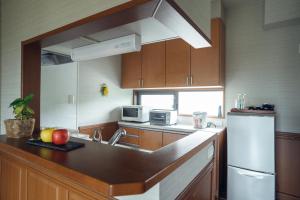 Una cocina con gabinetes de madera y encimera. en Condominium Takabatake, en Nara