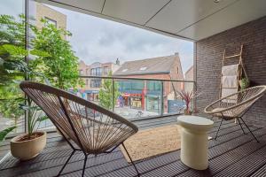 a balcony with two chairs and a large window at Aurora City Apartment in Lommel