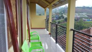 a balcony with green chairs and a view at Darajat Homestay in Darajat