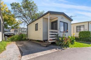 a tiny house is parked in a driveway at Moss Vale Holiday Park in Moss Vale