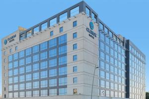Un edificio alto y blanco con un cartel. en Clarion Hotel Jeddah Airport, en Yeda