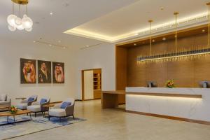 a lobby with a waiting room with chairs and a counter at Clarion Hotel Jeddah Airport in Jeddah +138 photos