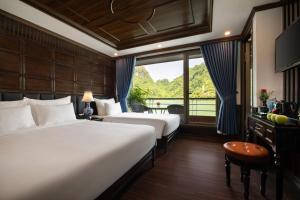a hotel room with two beds and a window at Midori Preminum Cruise in Ha Long Bay in Ha Long