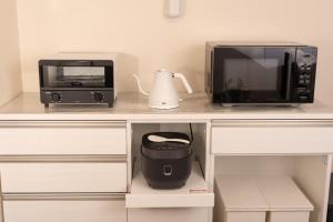 a kitchen counter with a microwave and a toaster oven at Skytree Tokyo Residence Aoto in Tokyo