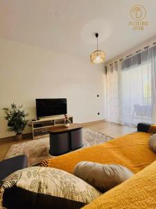 a living room with two couches and a flat screen tv at Jujubes d'Or, Appartement T2 in Saint-Paul