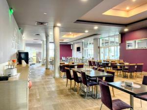 un ristorante con tavoli, sedie e pareti viola di Апартамент Елегант - спа комплекс Аква Терми a Krasnovo