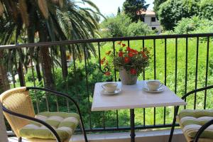 a table with two cups and a vase on a balcony at Swiss Residence Montenegro in Herceg-Novi