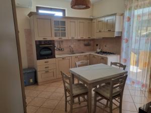 a kitchen with a table and chairs and a stove at La perla marina in Cellole