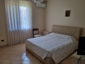 a bedroom with a large bed and a window at La perla marina in Cellole