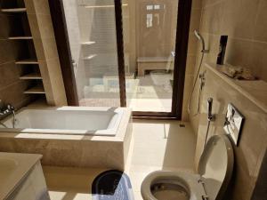 a bathroom with a bath tub and a toilet at Luxury Rotana Villa in Salalah