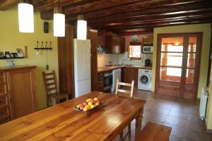 una cocina con una mesa de madera y un bol de fruta. en Casa Rural Sant Joan, en Olíus