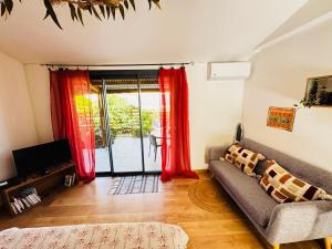 a living room with a couch and red curtains at Kaz O' vert in Saint-Pierre