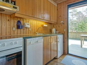 a kitchen with white appliances and a sliding glass door at 6 person holiday home in Nexø in Vester Sømarken