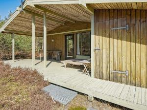 a wooden cabin with a picnic table on a deck at 6 person holiday home in Nexø in Vester Sømarken