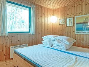 a bedroom with a bed in a wooden wall at 6 person holiday home in Nexø in Vester Sømarken