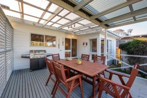 a patio with a wooden table and chairs at Hilltop Cottage - Beachside Escape with Fireplace in Blairgowrie