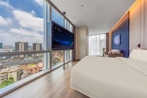 une chambre avec un grand lit et de grandes fenêtres dans l'établissement Atour Hotel Guangzhou Haizhu Taikoo Wharf-Free Shuttle Bus For Canton Fair-Self-service laundry 广州海珠太古仓亚朵酒店-广交会展期提供免费穿梭巴士, à Canton 80 autres photos