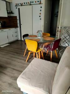 a living room with a table and chairs and a couch at La parenthèse in Ault