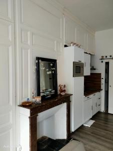 a kitchen with white cabinets and a counter with a microwave at La parenthèse in Ault