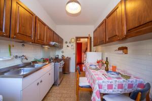 a kitchen with a table and a sink and a refrigerator at Villa La Verbanina Private Garden - Happy Rentals in Ghiffa