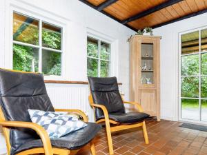 two chairs on a porch with windows at 6 person holiday home in Bindslev in Bindslev