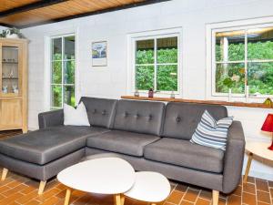 a living room with a couch and tables and windows at 6 person holiday home in Bindslev in Bindslev