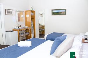 
a hotel room with two beds and a desk at Mansfield Travellers Lodge in Mansfield

