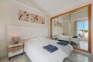 a white bedroom with a bed and a large window at Casa Latifa in Marbella +21 photos