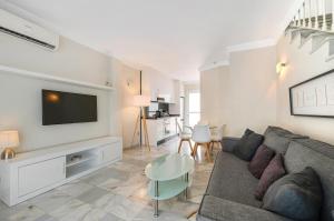 a living room with a couch and a tv at Casa Latifa in Marbella
