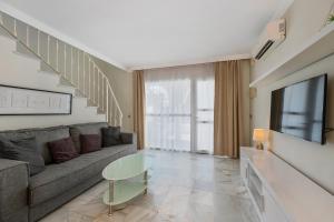 a living room with a couch and a tv at Casa Latifa in Marbella