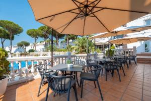 an outdoor patio with tables and chairs and umbrellas at Casa Latifa in Marbella