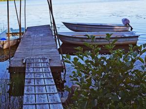two boats are docked next to a wooden dock at 6 person holiday home in TORSBY-By Traum in Överbyn