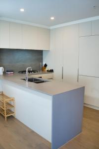 a kitchen with white cabinets and a sink at Park Avenue - Carnegie in Carnegie +69 photos