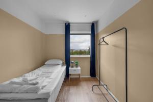 a small bedroom with a bed and a window at Unique Family House Near the Arctic Cathedral in Tromsø