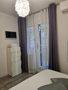 a bedroom with a bed and a chandelier at Villa Cristalli clinica pc in Piacenza
