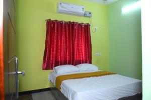 een bed in een kamer met een rood raam bij Thiruveesar Homestays in Tiruchchirāppalli +11 foto's