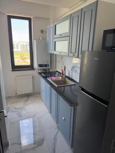a kitchen with a refrigerator and a sink at Virgo Apartaments Summer Land in Mamaia