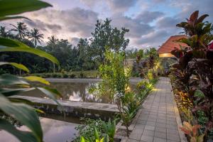 une passerelle devant une masse d'eau dans l'établissement Villa di carik ubud, à Ubud
