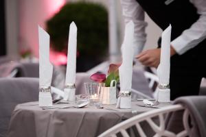 une table avec de l'argenterie et des fleurs au-dessus dans l'établissement relexa hotel München, à Munich