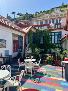 a patio with tables and chairs on a colorful rug at Check Point Hotel in Tbilisi City