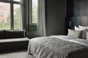 a bedroom with a bed and a chair and a window at Boutique Hotel Hans in Copenhagen