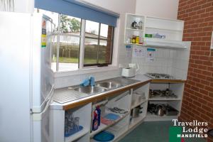 a kitchen with a sink and a refrigerator at Mansfield Travellers Lodge in Mansfield