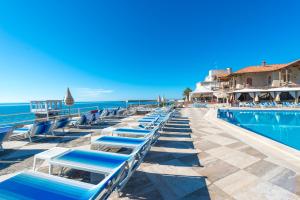 a row of lounge chairs next to a swimming pool at Hotel Ristorante Maga Circe in San Felice Circeo