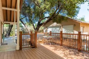 a wooden deck with a table and a tree at Groveland 2BR House with Hot Tub & Mountain Views in Groveland