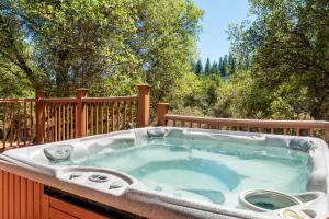 a jacuzzi tub on a deck with trees at Groveland 2BR House with Hot Tub & Mountain Views in Groveland