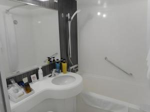 a bathroom with a sink and a toilet and a shower at JR-EAST HOTEL METS NAGAOKA in Nagaoka +58 photos