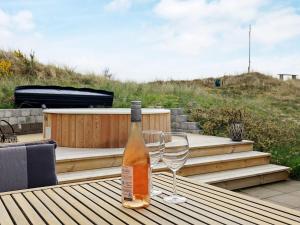 a bottle of wine sitting on a table with a wine glass at 8 person holiday home in Ålbæk in Ålbæk +20 photos