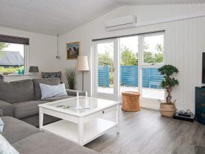 a living room with a couch and a table at 8 person holiday home in Ålbæk in Ålbæk