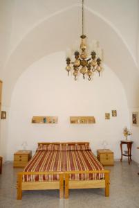 - une chambre avec un lit et un lustre dans l'établissement Casa Dei Furnari, à Collepasso