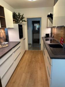 a kitchen with white cabinets and a wooden floor at Alpine Oasis in Hermagor